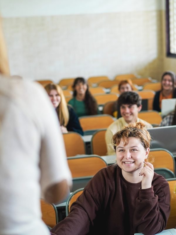 Mature teacher working with students inside classroom at school university