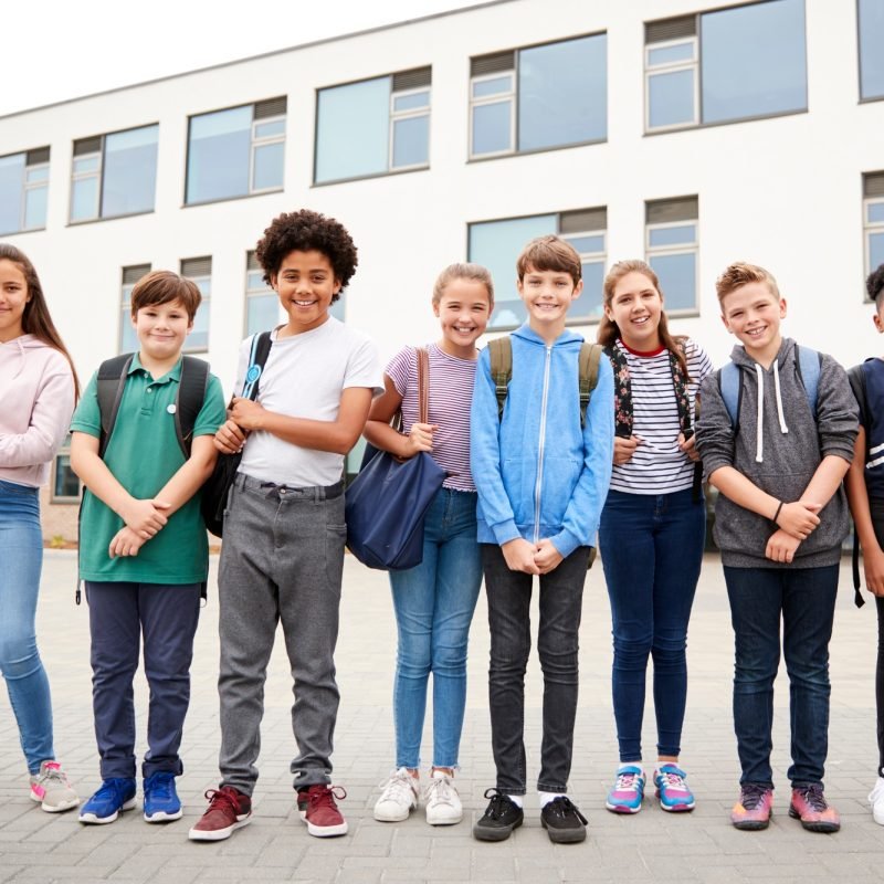 Portrait Of High School Student Group Standing Outside School Buildings